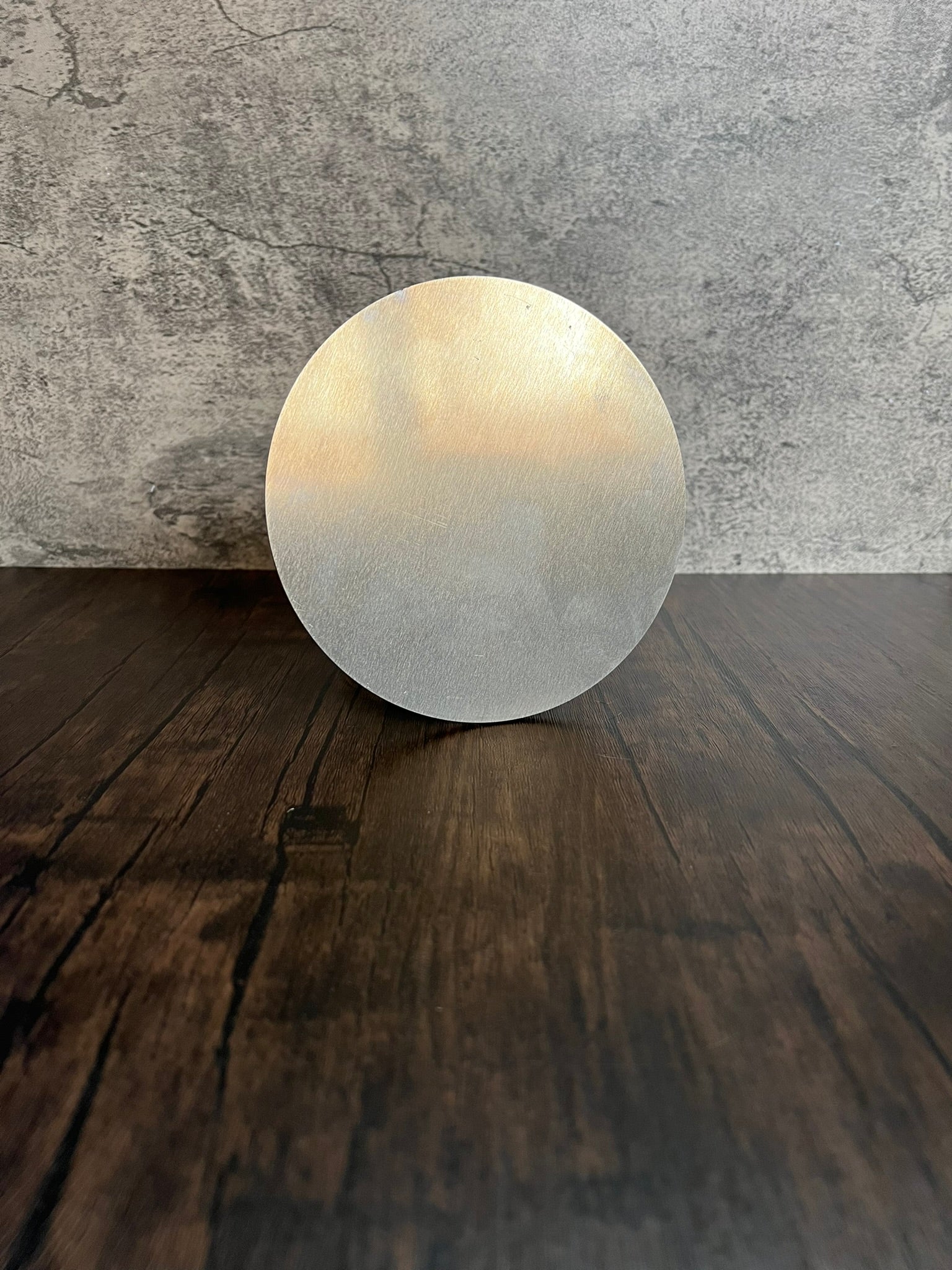 extra large round metal disc on wood and stone background