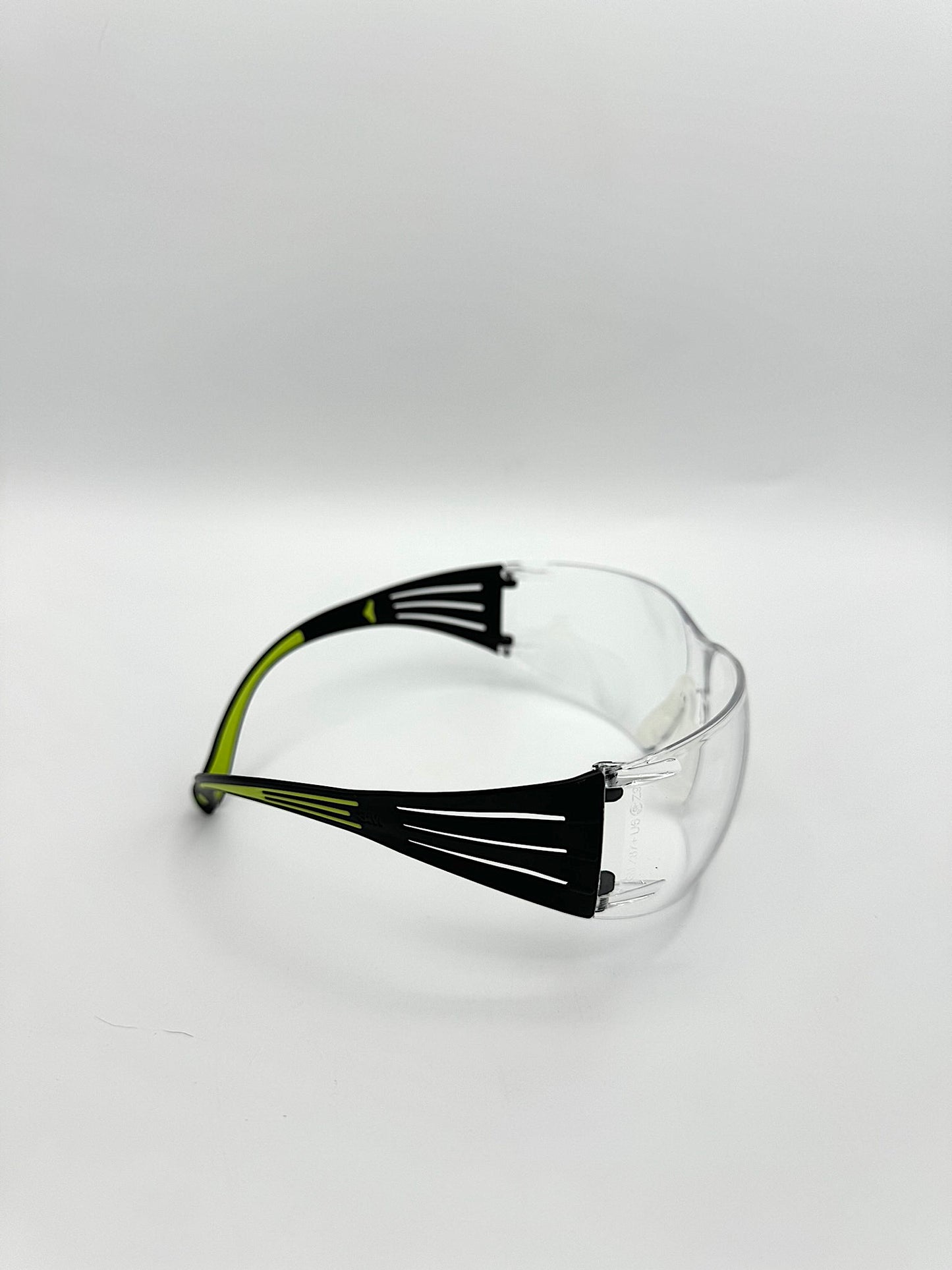 black and lime green side framed safety glasses with anti-fog clean lenses on a white background